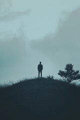  Person atop hill before tree, cloudy sky behind