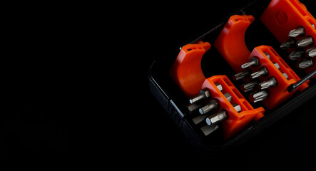 Naklejka premium Set of hexagonal, cross-head, and flat-head screwdrivers in a box for repair or assembly work on dark background.