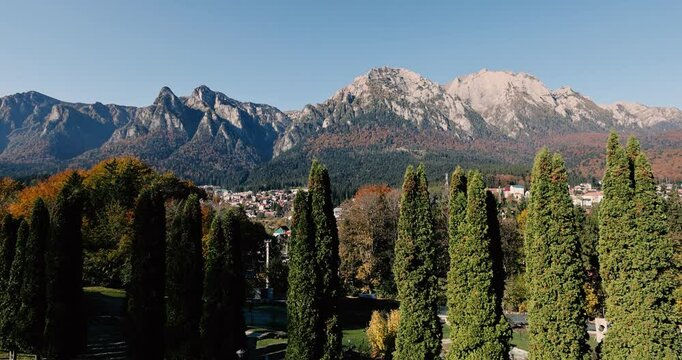 The Bucegi Mountains and Caraiman Peak in the background and Busteni city during a sunny autumn day.