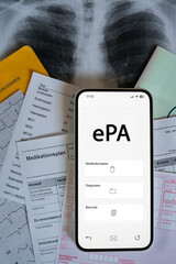Ein Smartphone auf dem gerade eine elektronische Patientenakte angezeigt wird, liegt auf...