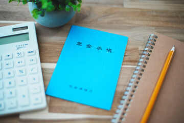 青色の年金手帳と電卓と筆記用具