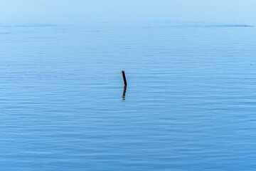 Lonely pipe protruding from the surface of the calm water of the Mediterranean Sea at the mouth of the Ebro River.