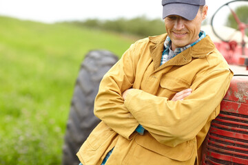 Farmer, man and tractor for work in countryside for sustainable business. Farm, nature and agriculture for eco friendly and harvest of crops in field with machine and vehicle for food production