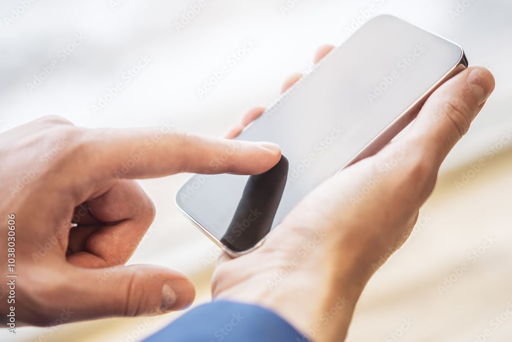 Poster man working intently on his advanced smartphone on the office environment