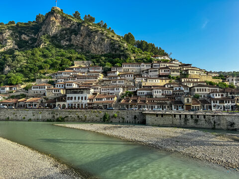 Panoramic view from footbridge Gorica over river Osum leading to Berat castle on hilltop in Albania. UNESCO World Heritage Site with well-preserved Ottoman-era architecture. City of thousand windows
