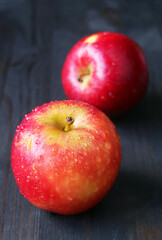 Pair of fresh ripe red apple isolated on black wooden background