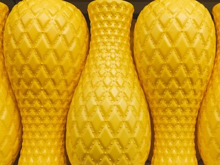  collection of yellow decorative vases with diamond-textured patterns arranged in a row, creating a symmetrical and vibrant display