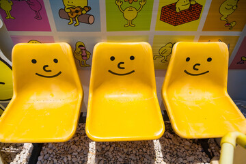 Nonthaburii, Thailand - June, 24, 2024 : Vibrant Yellow Chairs with Happy Faces at Nonthaburii,...