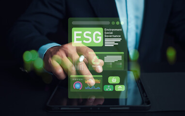 Man hand using stylus pen to analyze ESG on screen in business investment strategy concept, ESG...