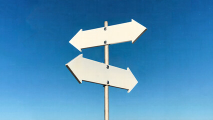 A blank sign with two white arrows pointing in opposite directions.