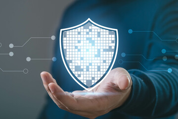 Person holding a digital shield symbolizing data security and protection in technology, illustrated...
