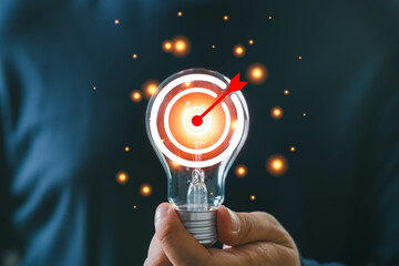 Innovative concept of targeting success with a light bulb representing ideas and creativity,...