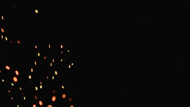 Slow motion of hot sparks from charcoal moving up on black background, 180fps