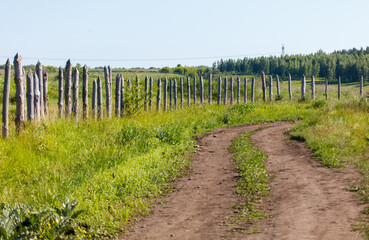 Obraz premium A dirt road with a fence in the background