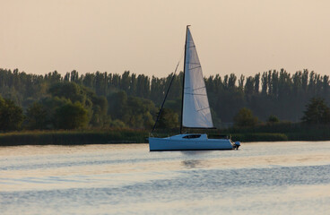 A sailboat is sailing on a calm lake