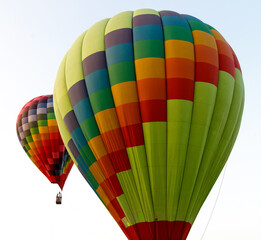 Obraz premium Two hot air balloons are floating in the sky, one of which is green