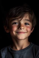 A close-up portrait of a young boy smiling softly, illuminated by natural light, showcasing innocence and warmth against a dark, minimalistic background.