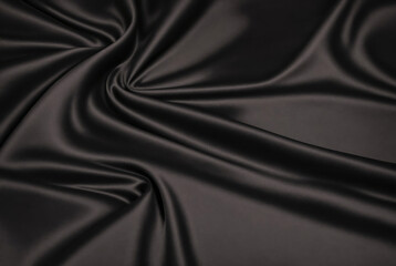 Luxurious black fabric texture background. Close-up of soft wave of black silk fabric. Satin, silk and cotton folds