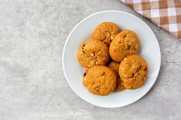Cookies oatmeal raisin in white plate on grey background