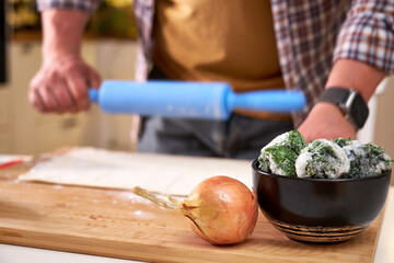 a man rolls out dough on a wooden board