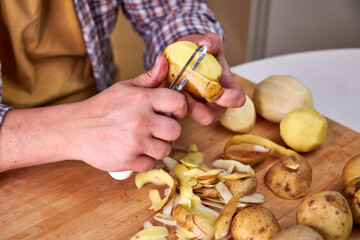 man in the kitchen peeling potatoes