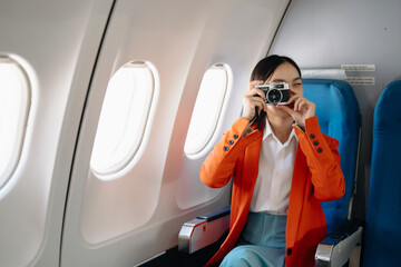 Naklejka premium Asian woman sitting in a seat in airplane and looking out the window going on a trip vacation travel concept.Capture the allure of wanderlust .