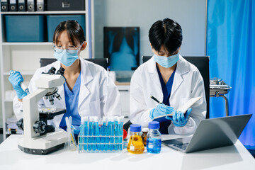 scientists in lab coats conducting research, handling glassware, and working with chemicals