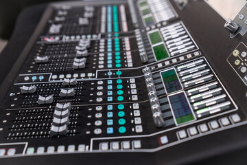 The professional audio mixing console features numerous sliders and controls, indicating a live...