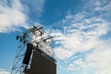 Overhead stage rigging equipment  Concert stage with outdoor lighting and sound equipment on cloudy sky background and afternoon sun with copy space