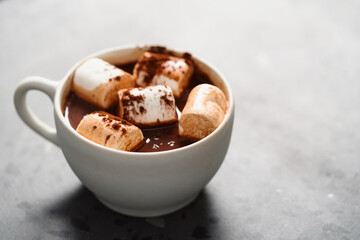 Cocoa drink with marshmallow in white cup on terrazzo surface with copy space