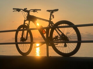 Obraz premium Silhouette of bicycle and Beautiful sky on sunrise times