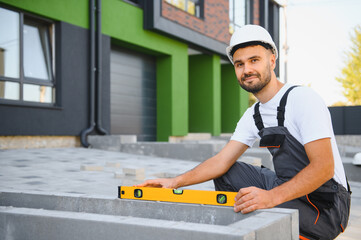 Builder on the background of new cottages. The concept of the construction of private cottages