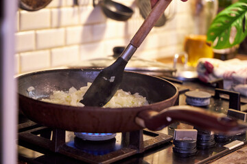 a man fries vegetables in a skillet on the stove