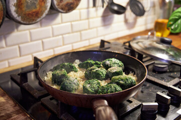 a man fries vegetables in a skillet on the stove