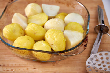 boiled potatoes lying in a clear dish on a board