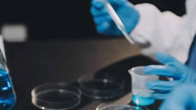 Group of dedicated scientist conduct chemical experiment in medical laboratory, carefully drop precise amount of liquid from pipette into test tube for vaccine drug or antibiotic development. Neoteric