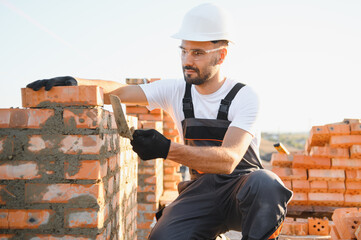 Construction worker man in work clothes and a construction helmet. Portrait of positive male...