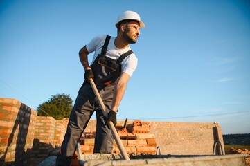 Construction worker in uniform and safety equipment have job on building. Industrial theme