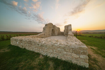 Ruins of an ancient medieval church from the Árpád era in Tök, Hungary. It is sunrise. The...