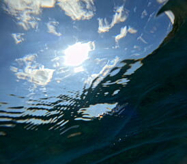 Naklejka premium sunny sky with clouds seen from under the sea surface with action camera. ocean backgrounds