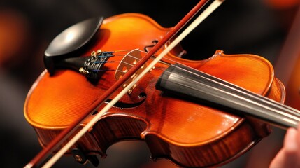 Fototapeta premium Close-up of a violinist's bow gliding over the strings, with the instrument's polished wood reflecting the light, emphasizing craftsmanship. --chaos