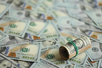 Money close up. A roll of one American dollars on 100 USD banknotes
