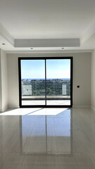 Spacious and elegant empty room with large floor-to-ceiling windows offering a panoramic view of a serene landscape, ideal for modern living or office spaces.