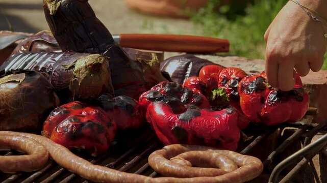 A rustic outdoor scene of vegetables grilling over a wood fire, an essential step in making traditional Romanian zacusca. The fire-roasted vegetables bring out deep, smoky flavors