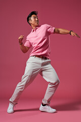 a man in pink color casual outfit standing in the studio with isolated background