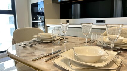 Elegant dining setup in a modern kitchen with marble table and designer glassware, ideal for interior design themes and lifestyle magazines.