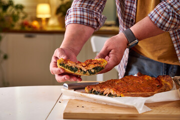a piece of fish pie in the chef's hand. Close-up