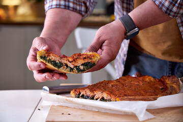 a piece of fish pie in the chef's hand. Close-up