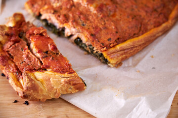 a piece of fish cake on a wooden board. Close-up