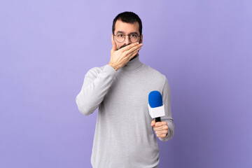 Adult reporter man with beard holding a microphone over isolated purple background covering mouth...